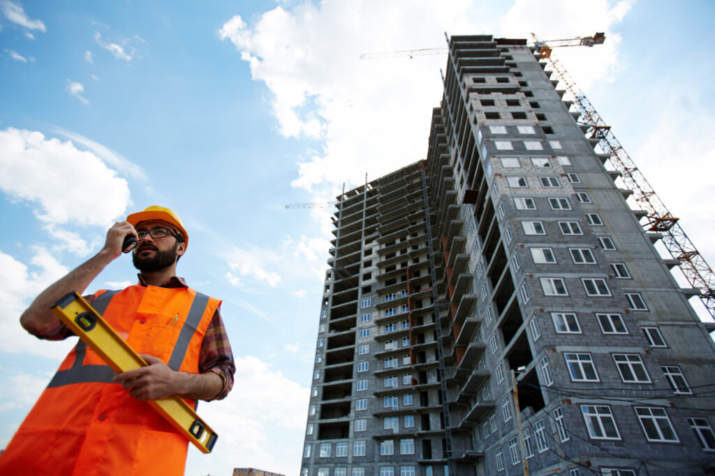 Civil Engineer Speaking outdoors on walkie talkie at residential construction site